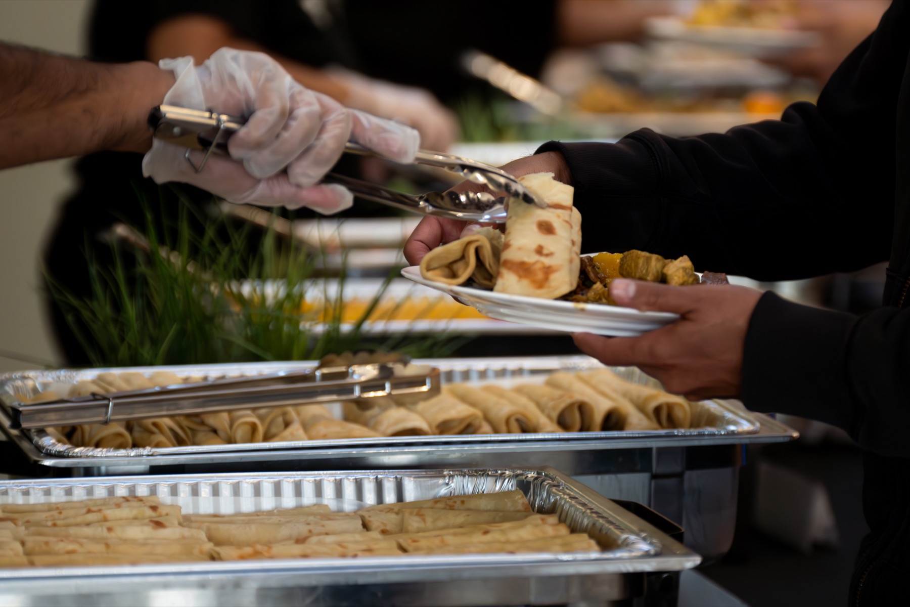 The Roti Hut catering team serving roti at an event