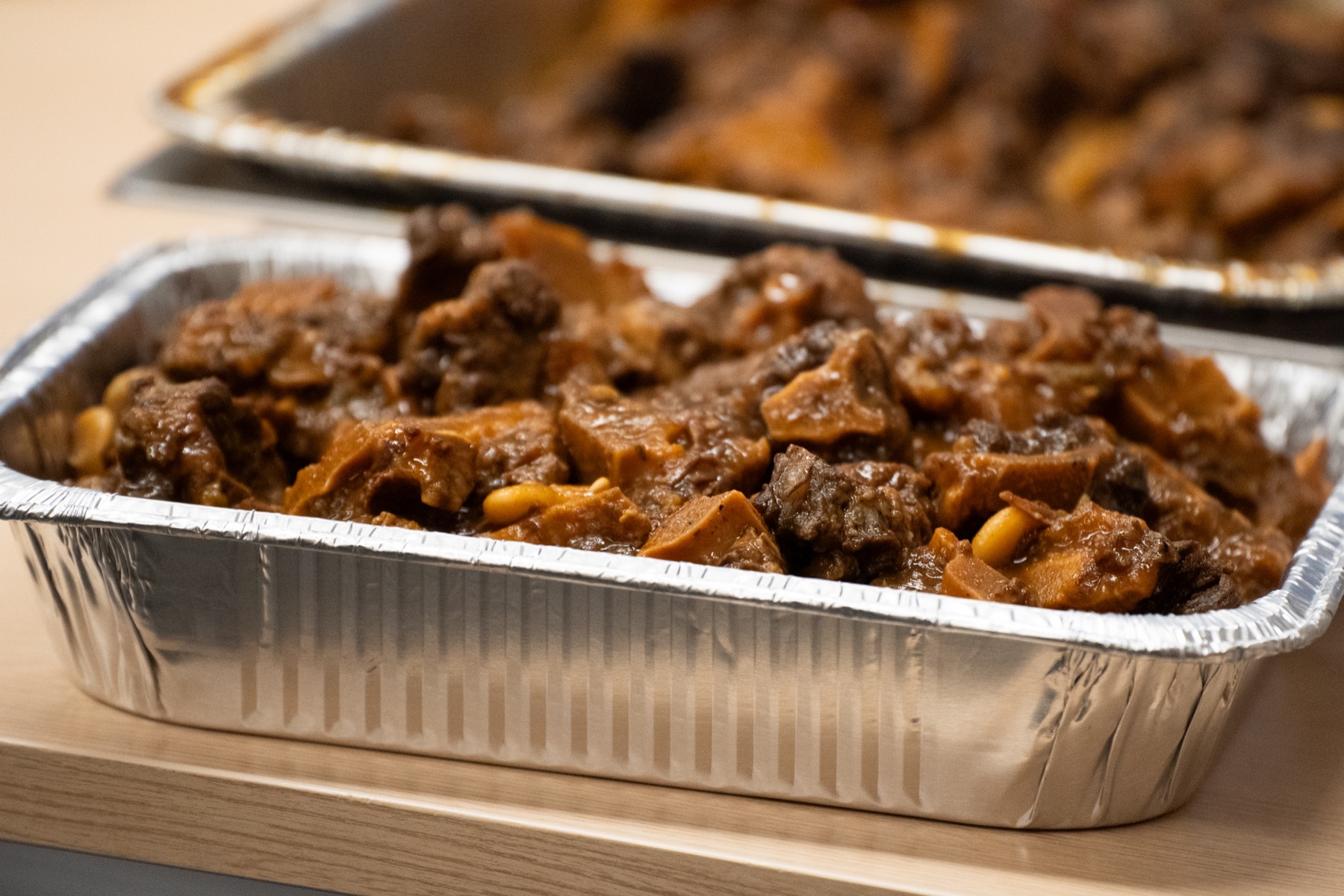 A catering tray filled with curry goat